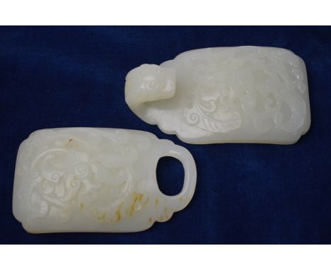 A green jade belt buckle of whitish hue, in two parts; each reverse designed with a single boss, overall length 14cm long