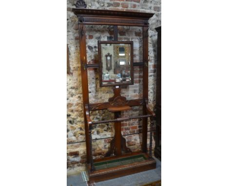 A Victorian carved walnut hallstand set with a bevelled mirror and shelf, lower umbrella rack with twist rails and tin tray, 