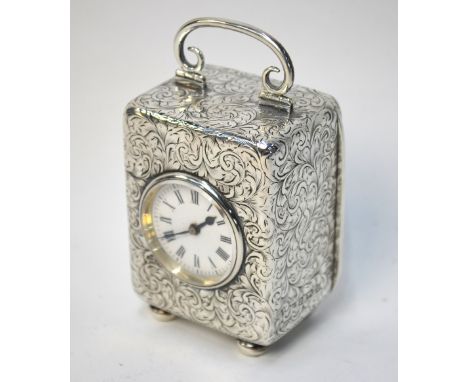 An Edwardian silver-cased boudoir clock with French movement, enamel circular dial, the case ornately decorated with foliate 