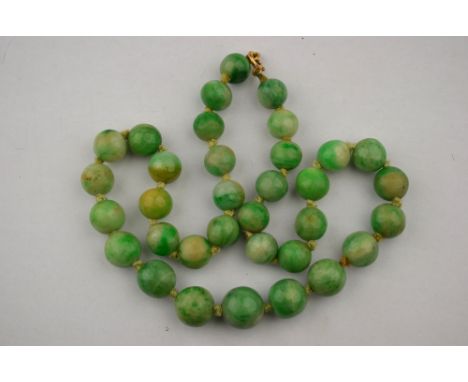 A single row of graduated green jade beads, graduated from 1.2 cm-0.8 cm knotted throughout onto gold bolt ring, 48 cm long