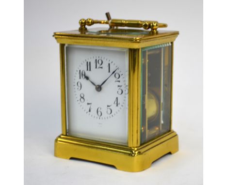 A brass carriage clock, striking on a coiled gong, enamel dial inscribed for Vokes of Bath, 16 cm high