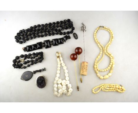 A lot containing various antique items including carved jet necklaces, black glass bracelet, glass cameo in high relief, moth