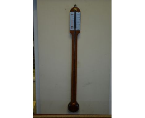 A reproduction walnut stick barometer by Russell of Norwich, with mercury column and alcohol thermometer