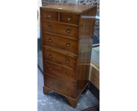 A modern yew veneered and brass-bound chest of two short and five long drawers with sliding shelf