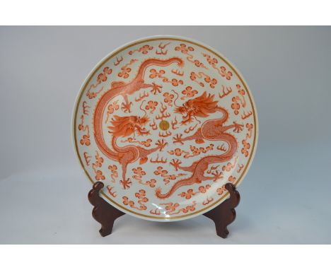 A Chinese orange and gilt decorated circular dish, decorated with a pair of five-clawed dragons beside a flaming pearl; the b