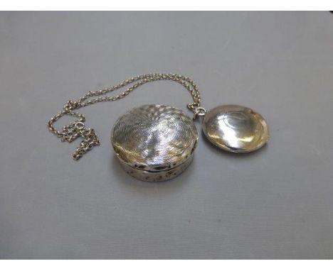 A silver locket with charm and a silver trinket pot with engine turned decoration. 