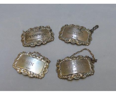 A set of four silver decanter tags for Gin, Vodka, Whisky and Sherry, Birmingham hallmarks, various years.