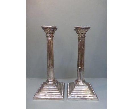 A pair of silver plated Corinthian column candlesticks. 