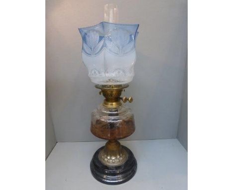 A Victorian oil lamp with glass reservoir and blue tinted etched shade. 