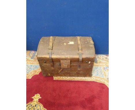 A canvas dome topped travel trunk with straps and some original labels. 