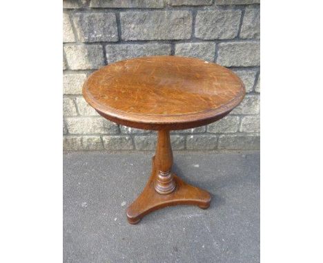 A 19th Century oak circular occasional table raised on a bulbous, turned column to a tripod base. 