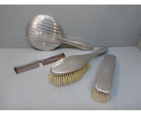 A four piece silver backed dressing table set with engine turned decoration, maker G.M & Co., Birmingham 1919.