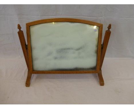 A light oak framed toilet mirror.