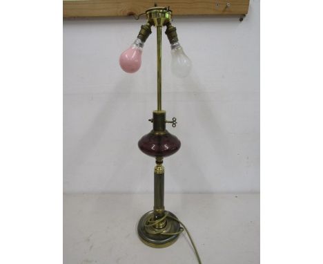 A brass based lamp with cranberry glass globe detail, no shade