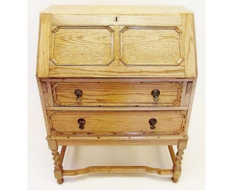 A 1930's light oak Jacobean style bureau with two panelled drawers on barley twist supports 