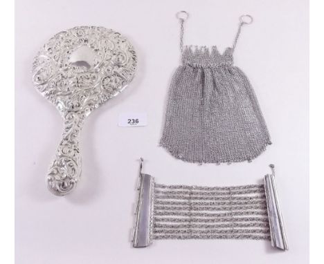 A silver backed mirror, a white metal chain purse and a bracelet