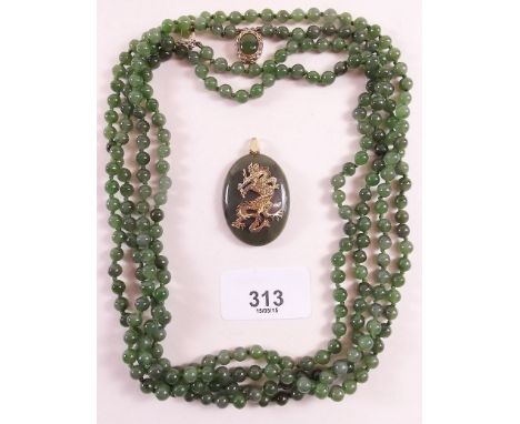 A 'Jade' necklace and pendant with gold plated dragon