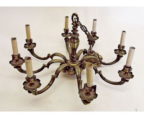 A large heavy brass eight branch chandelier light fitting 