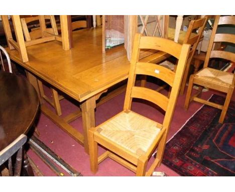 A contemporary honey oak plank top draw leaf refectory table having cleated ends, raised on notch square cut supports, max le