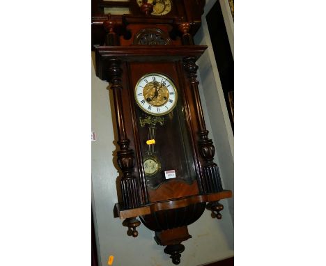 An early 20th century walnut Vienna droptrunk wall clock, with pendulum and keys