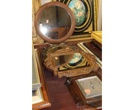 A walnut framed circular wall mirror, dia. 36cm, together with carved oak wall mirror, gilt metal wall mirror, and an oak wal