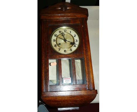 A 1930s oak droptrunk wall clock, with pendulum and key
