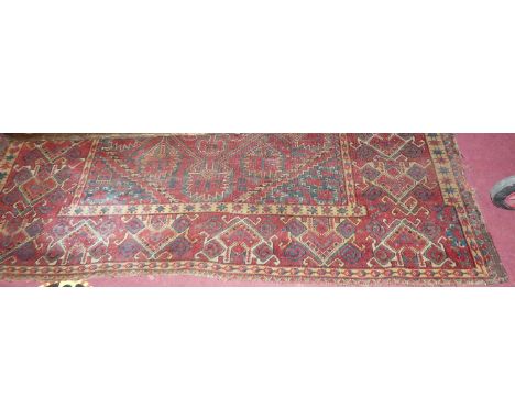 A large Persian woollen red ground Bokhara rug, having all over floral stylised ground (with fading, wear and losses), 396 x 