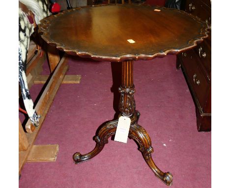 An early Georgian style mahogany circular piecrust topped tilt-top pedestal tripod table, having partial fluted and acanthus 