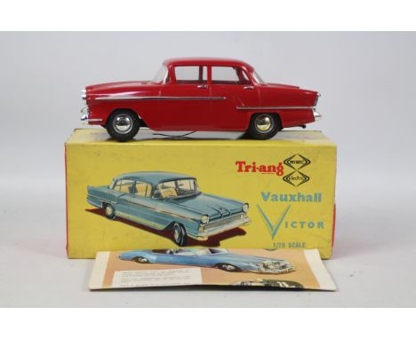 Tri-Ang: A Tri-ang Minic Vauxhall Victor 1:20 scale saloon car in Red with tartan seats in original yellow picture box, batte