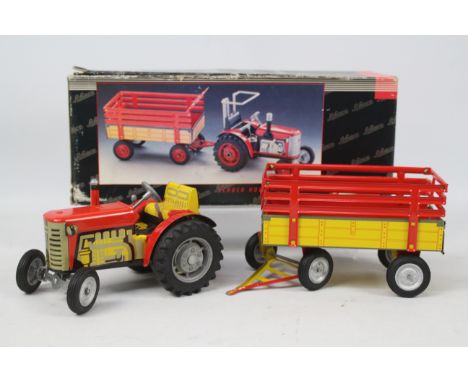 Schuco - A boxed clockwork tinplate Tractor and trailer # 07041. The models appear in Mint condition but the removable roll o