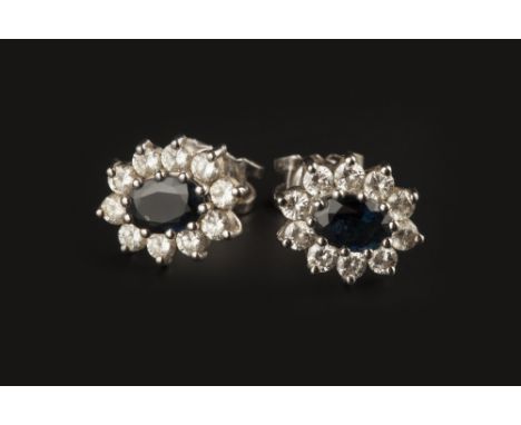 A PAIR OF SAPPHIRE AND DIAMOND CLUSTER EARSTUDS, each oval mixed-cut sapphire claw set within a round brilliant-cut diamond b