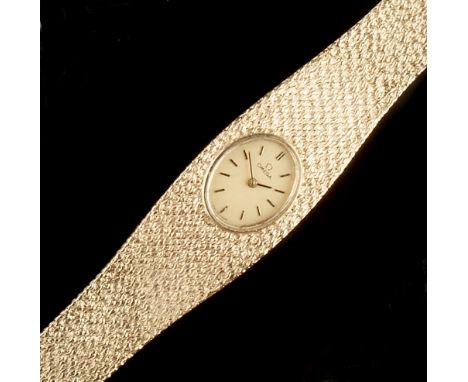 A LADY'S 9CT GOLD BRACELET WATCH BY OMEGA,  the oval gilt dial of brushed finish with baton markers, to an integrated case an