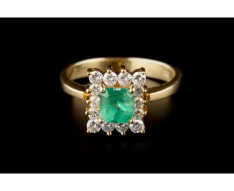 AN EMERALD AND DIAMOND CLUSTER RING,  the octagonal step-cut emerald claw set within a round brilliant-cut diamond border, ye