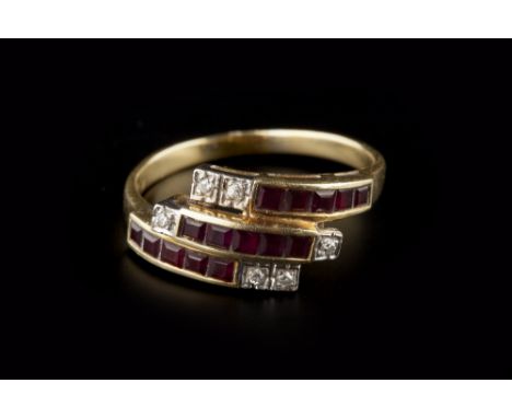 A RUBY AND DIAMOND DRESS RING, of crossover design, with three rows of channel set calibre-cut rubies, framed by round brilli