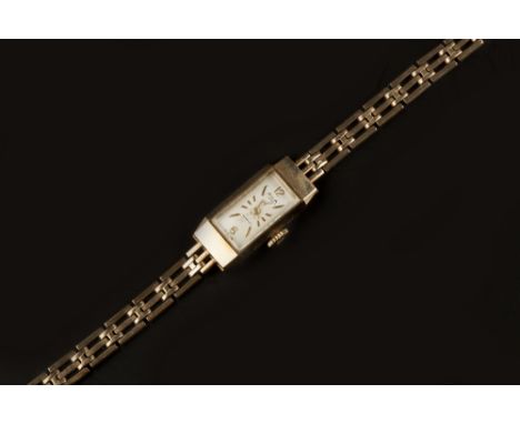 A LADY'S 9CT GOLD BRACELET WATCH BY AVIA, the rectangular silvered dial with Arabic numerals and baton markers, on a gate-lin