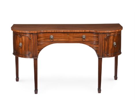 A LATE GEORGE III MAHOGANY SIDEBOARD  CIRCA 1810  Of swept inverted breakfront form, with a frieze drawer flanked by a pair o