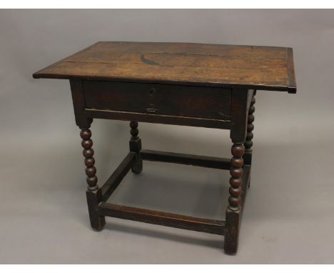 AN EARLY 18TH CENTURY OAK SIDETABLE. With a rectangular three plank top above a single side-hung frieze drawer, the interior 