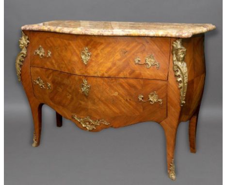 A LOUIS XVI STYLE MARBLE TOPPED COMMODE. The variegated marble top with serpentine front and moulded border above two bow fro
