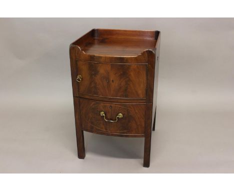 A GEORGE III MAHOGANY BOW FRONT BEDSIDE COMMODE. The bow front top with raised frieze above a single cupboard door modelled a