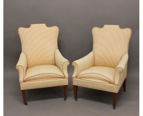 A PAIR OF LATE VICTORIAN/EDWARDIAN UPHOLSTERED ARM CHAIRS. Each with raised, shaped, rectangular backs, arm supports and seat