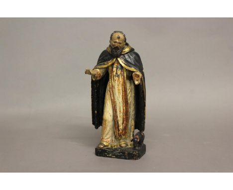 AN EARLY 18TH CENTURY FRENCH CARVED DEVOTIONAL FIGURE. A polychrome figure of St Anthony in a black gold trimmed cloak, stand