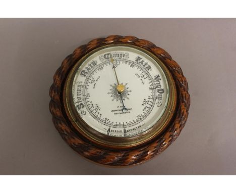 AN OAK FRAMED BAROMETER BY ADIE OF WESTMINSTER. With a carved 'rope twist' surround and decorative dial signed 'P. Adie Broad