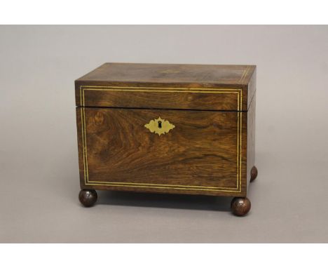 A REGENCY ROSEWOOD AND BRASS INLAID TEA CADDY. A rectangular tea caddy of generous proportions with brass strung front and li