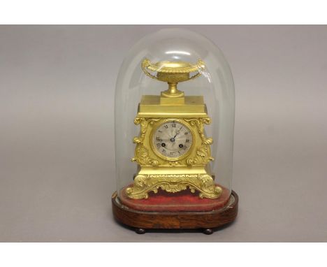 A REGENCY GILT BRASS MANTLE CLOCK AND GLASS DOME. The clock with a silvered dial with engine turned centre and Roman numerals