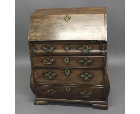 A GEORGE II MAHOGANY BUREAU with fall flap concealing a fitted interior, bombe sides and front with font drawers on ogee brac