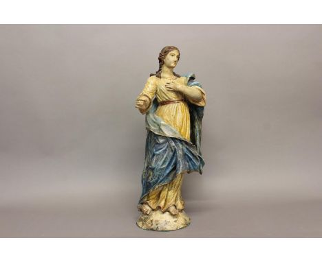 A 19TH CENTURY CARVED POLYCHROME FIGURE OF A SAINT. The female figure standing in a simple white robe and flowing blue cloak,