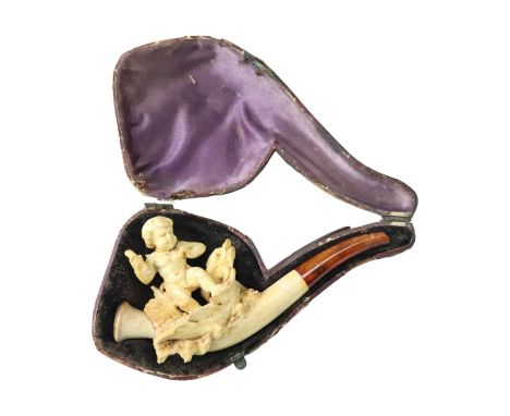 A Victorian carved meerschaum cigarette pipe, its bowl modelled as Cupid, having an amber stem and in original case, (a/f)