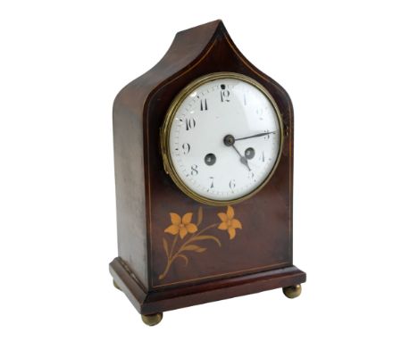 An Edwardian mahogany mantle clock having a barrel movement and striking on a gong, the ogee arch case decorated with floral 