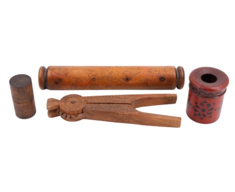 Three items of treen comprising a carved Indian nutcracker, decorated scroll or similar mount, and a hair-tidy together with 