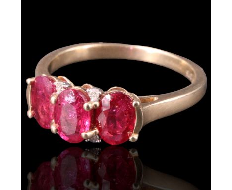 A three-stone natural ruby ring, comprising three oval cut stones each of approx 0.6 ct, bar-and pellet-set with four small d